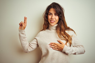 Young beautiful woman wearing winter sweater standing over white isolated background smiling...