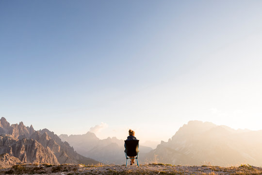Tre Cime di Lavaredo ("Drei Zinnen"), Sexten Dolomites, Italy: A woman in a campchair wathcing the sun go down.