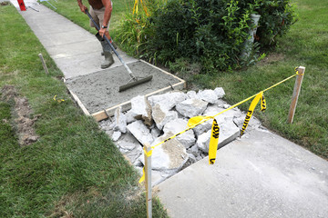 concrete work is being performed at a home in a urban neighborhood