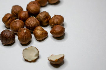 Several varieties of nuts are located on a white sheet of paper.