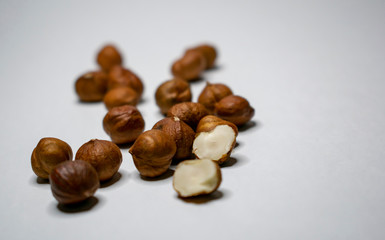 Several varieties of nuts are located on a white sheet of paper.