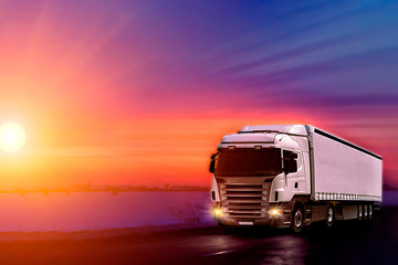 Truck with container on highway, cargo transportation concept. Sunset background with copy space