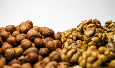 Several varieties of nuts are located on a white sheet of paper.