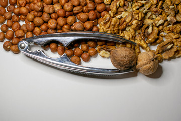 Several varieties of nuts are located on a white sheet of paper.