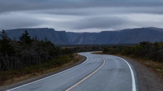 Scenic curvy road in the Canadian Landscape during a cloudy sunset. Taken in Gros Morne National Park, Newfoundland, Canada. Still Image Continuous Animation