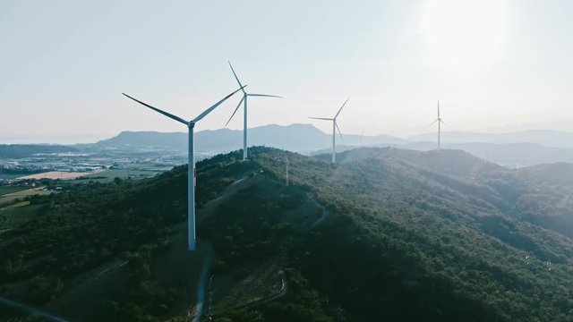 Wind turbine farm on beautiful evening mountain landscape. Renewable energy production for green ecological world. Flat color. 4k