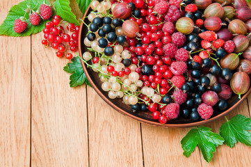 Fresh organic berries on a plate on a wooden table