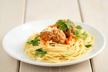 meatballs with pasta on a white plate on a background of white boards. Delicious Meat Balls Decorated with Herbs