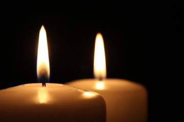 Two large white candles with small copy space