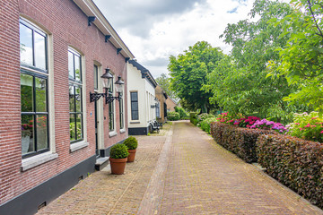Beautiful historic buildings on the Herengracht in the picturesque and flowered village Drimmelen, Netherlands