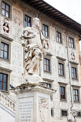 Obraz premium The statue of Cosimo I de Medici in front of Palazzo della Carovana built in 1564 located at the palace in Knights Square in Pisa