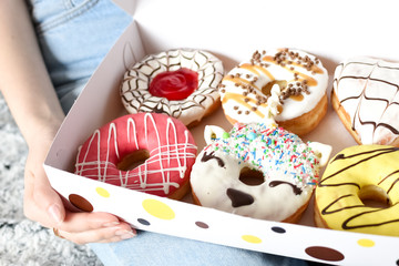 Female hand holding delicious donut