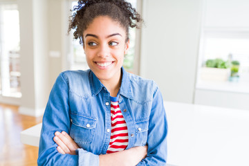 Beautiful young african american woman with afro hair wearing casual denim jacket smiling looking side and staring away thinking.