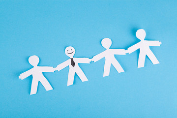 Standing out from the crowd concept, paper people on a blue background. Individuality, uniqueness, positive