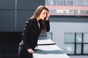 anxious businesswoman, suffering from acrophobia, standing on rooftop and looking down - obrazy, fototapety, plakaty
