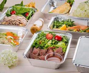 Set of diet dishes in containers on a light wooden background. Takeaway. Diet and healthy food.