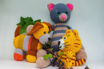 Amigurumi dog and cat next to a sprig of black currant.