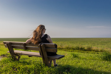 blonde girl sitting on a bench