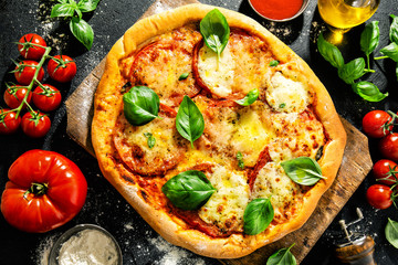 Homemade pizza with mozzarella on dark background