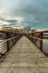 Wooden bridge over lake with moody sunset