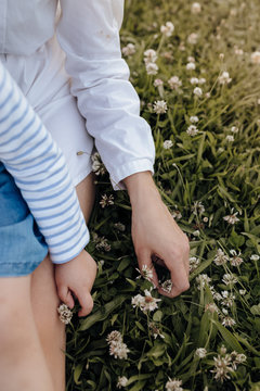 Midsection of mother and daughter touching flowers