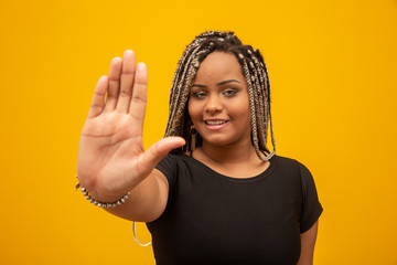 Obraz premium Young African American woman shown hand on sign for them to stop with racial prejudice.