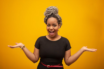 Beautiful african american young woman over isolated yellow background excited for success with...
