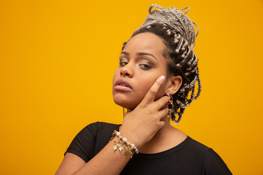 Beautiful Young African American Woman With Dread Hair On Yellow Background