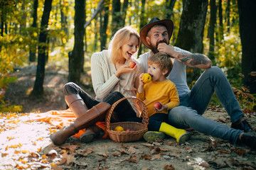 Family day concept. Happy family with kid boy relaxing while hiking in forest. Basket picnic...