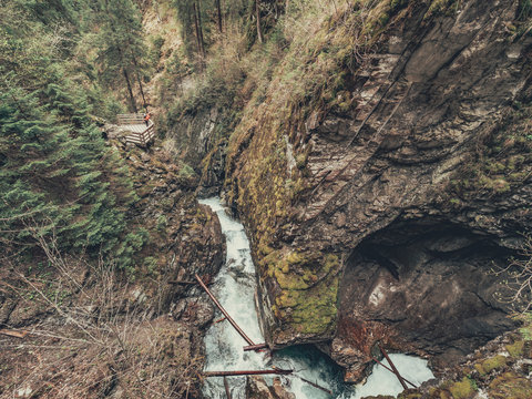Tourist admiring majestic view of Alps and mountain stream while walking on hiking path in Dolomites, Italy