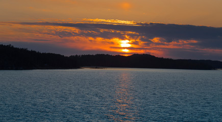 the light of the setting sun shines through the clouds