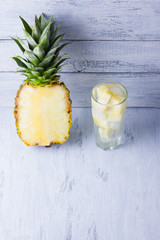 Drink with pineapple slices and ice. Pineapple and detox water on a white background. Tropical fruit with water. Healthy drink to cleanse the body. Copy space