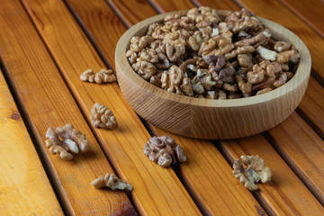 Walnut kernels in wooden plate on wooden table