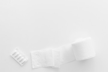 Proctology concept with toilet paper roll and rectal suppository on white background top view copyspace