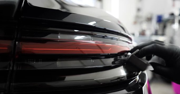 Staff wear Chemical protective clothing at work. Automobile industry. Car wash and coating business with ceramic coating.Spraying the varnish to the car. Concept of: Car protective, Service, Shine.