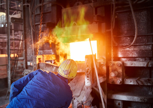 Industry, Smeltery: Worker checking blast furnace for fractures