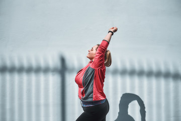 Morning yoga. Side view of young plus size woman in sports clothing stretching while warming up...