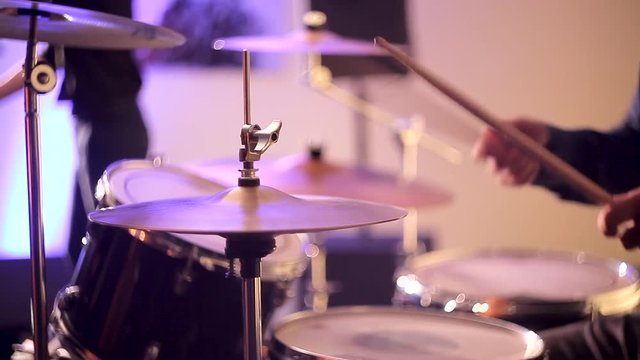 The drummer plays chopsticks on the drums. Beats drum sticks on the plates and drum set. A jazz orchestra drummer plays chopsticks on drums.