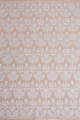 a background image of ivory-colored lace cloth. White lace on beige background.