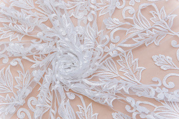 a background image of ivory-colored lace cloth. White lace on beige background.