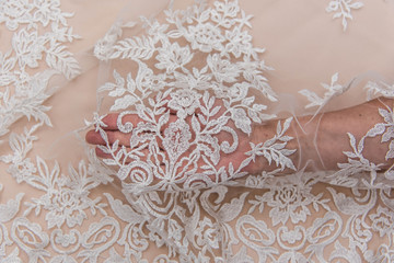 a background image of ivory-colored lace cloth. White lace on beige background.