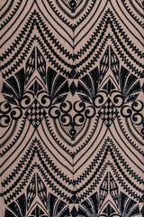 a background image of lace cloth. Black lace on beige background.