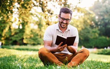 Man reading a book in the park. Education, lifestyle concept