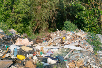 Landfill and construction waste on the outskirts of the forest