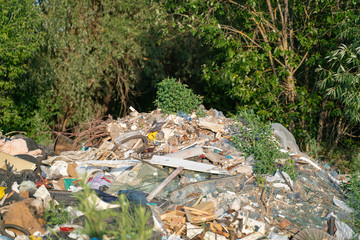Landfill and construction waste on the outskirts of the forest