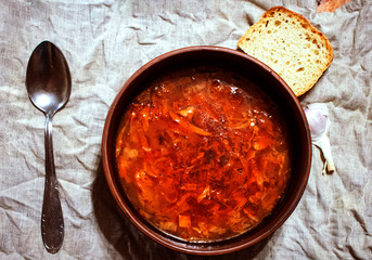 Rustic soup on the background of the napkin from flax. Borscht with garlic and bread..