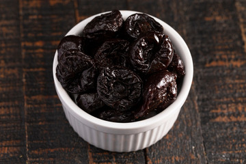 Bowl of Prunes on a Rustic Wooden Table