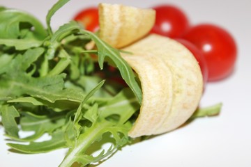 salad with tomatoes and cucumbers, banana chips with arugula and  tomatoes, food