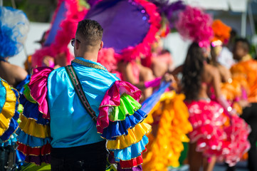 Abstract view of samba dancers in colorful frilled costumes at a daytime Carnival street party in...
