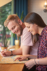 two friends sitting together in cafe, happy while searching on a city lap.